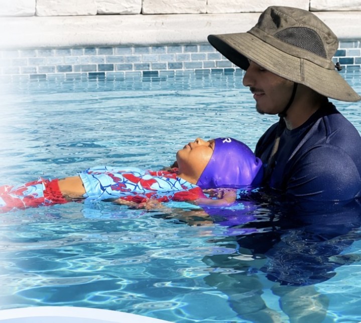 Swim instructor teaching a child to swim in a pool in North Carolina